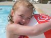 A young girl with a beach ball at the campsite swimming pool